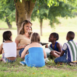 Children and education, teacher reading book to young students